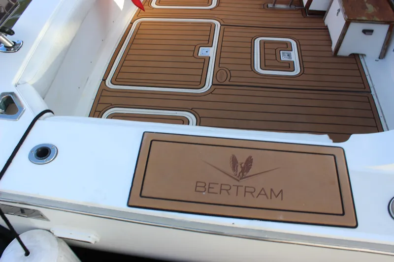 Slide: The Image of 1988 Bertram 33II Flybridge Cruiser deck with logo and teak flooring. - 19