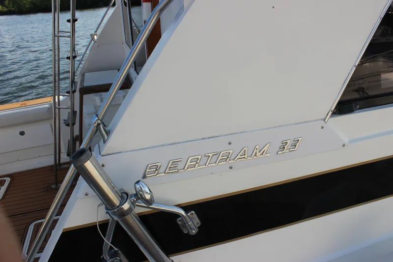 Slide: The Image of 1988 Bertram 33II Flybridge Cruiser boat side view with logo. - 22