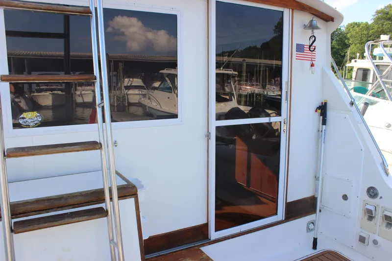 Slide: The Image of 1988 Bertram 33II Flybridge Cruiser, rear view with ladder and sliding door. - 26