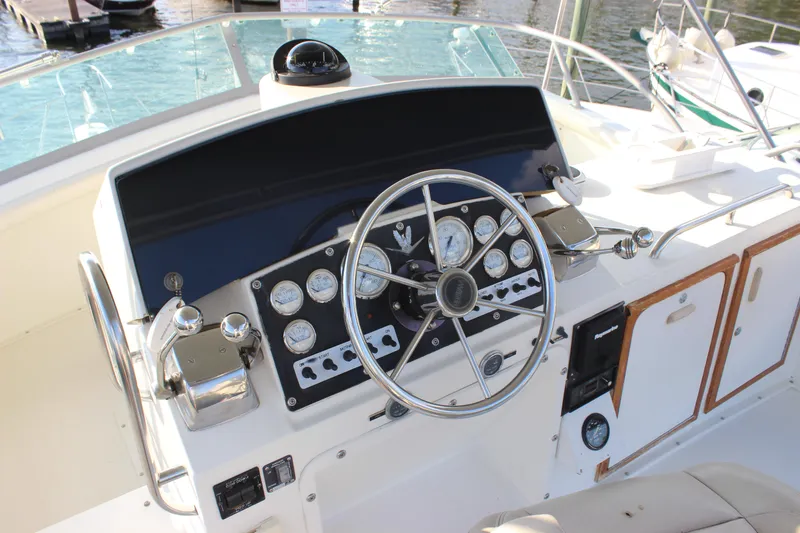 Slide: The Image of 1988 Bertram 33II Flybridge Cruiser helm with steering wheel and control panel. - 28