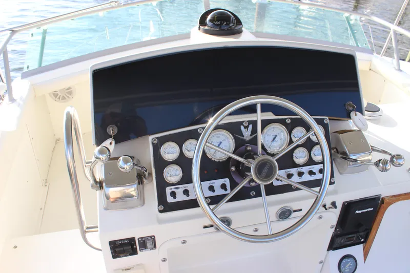 Slide: The Image of 1988 Bertram 33II Flybridge Cruiser helm with steering wheel and instrument panel. - 32