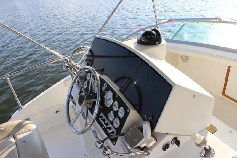 Slide: The Image of 1988 Bertram 33II Flybridge Cruiser helm with steering wheel and instrument panel. - 36
