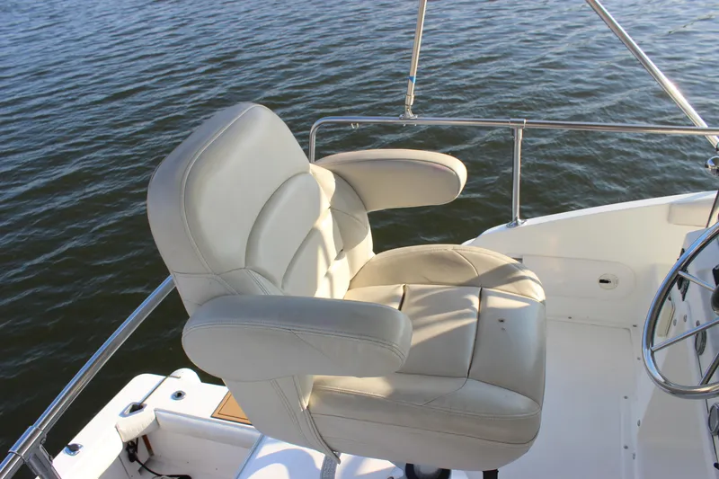 Slide: The Image of Captain's chair on 1988 Bertram 33II Flybridge Cruiser, overlooking water. - 37