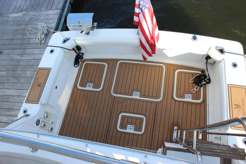 Slide: The Image of 1988 Bertram 33II Flybridge Cruiser deck with teak flooring and American flag. - 40