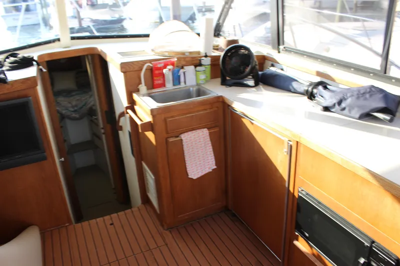 Slide: The Image of Interior of 1988 Bertram 33II Flybridge Cruiser with wooden cabinetry and sink. - 43