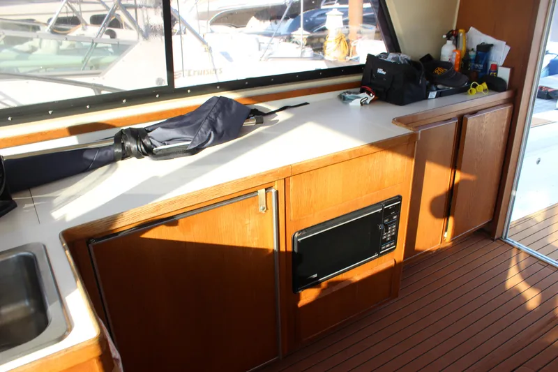 Slide: The Image of Interior of 1988 Bertram 33II Flybridge Cruiser with wooden cabinets and microwave. - 44