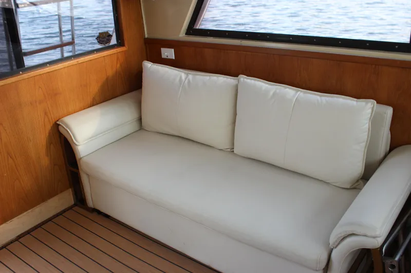 Slide: The Image of White leather sofa in the cabin of a 1988 Bertram 33II Flybridge Cruiser. - 46