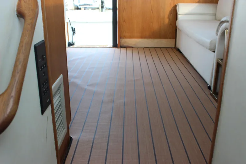 Slide: The Image of Interior of 1988 Bertram 33II Flybridge Cruiser with striped flooring and white seating. - 49