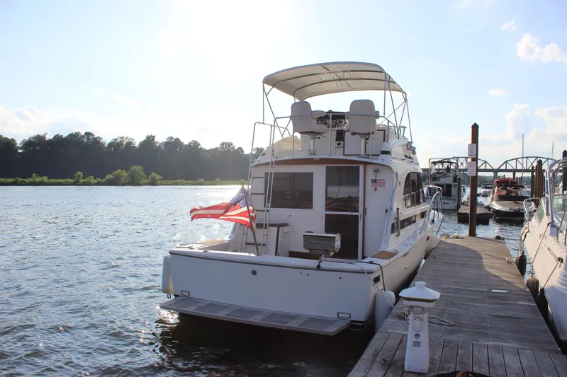 Slide: The Image of 1988 Bertram 33II Flybridge Cruiser docked at a marina on a sunny day. - 5