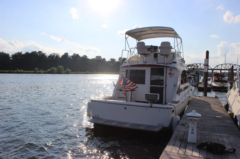 Slide: The Image of 1988 Bertram 33II Flybridge Cruiser docked at a marina on a sunny day. - 7
