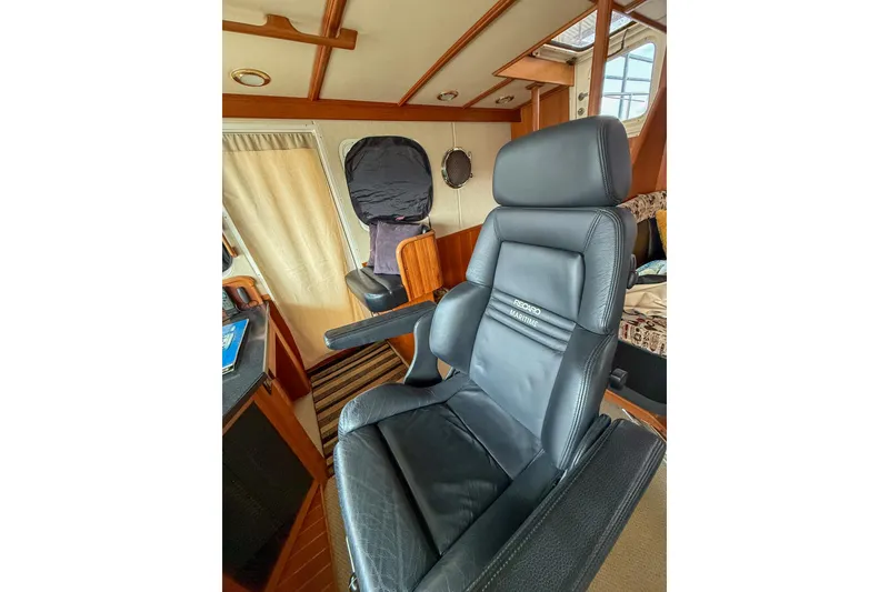 Slide: The Image of 2007 Nordic Tug 54 docked in a covered marina, side view with red buoy. - 17