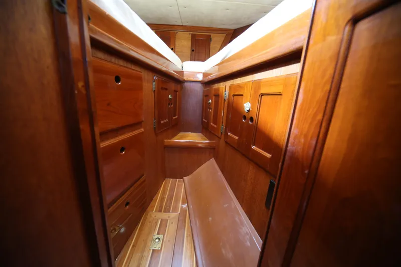 Slide: The Image of Interior of 1979 Westsail 32 Shipmaster, featuring wooden cabinetry and storage compartments. - 32