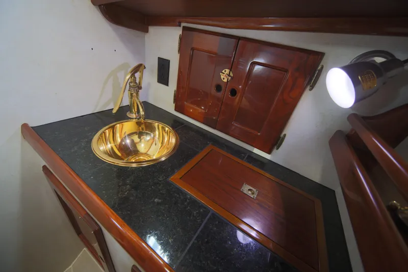 Slide: The Image of Luxurious 1979 Westsail 32 Shipmaster bathroom with brass sink and wooden cabinetry. - 35