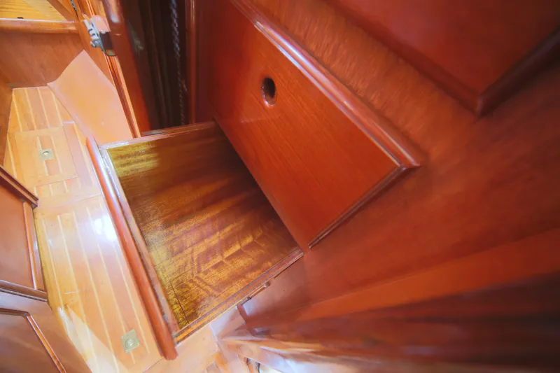 Slide: The Image of Interior of 1979 Westsail 32 Shipmaster, featuring polished wooden cabinetry and flooring. - 36