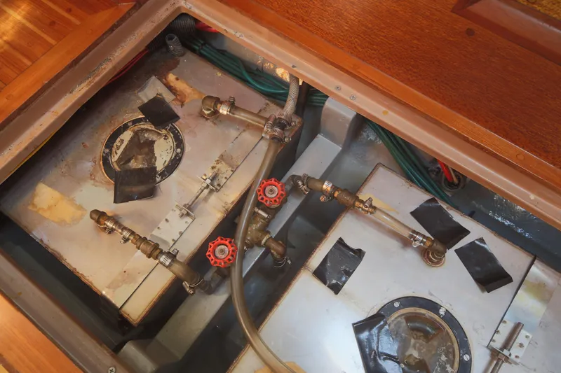 Slide: The Image of 1979 Westsail 32 Shipmaster engine compartment with fuel tanks and valves. - 44