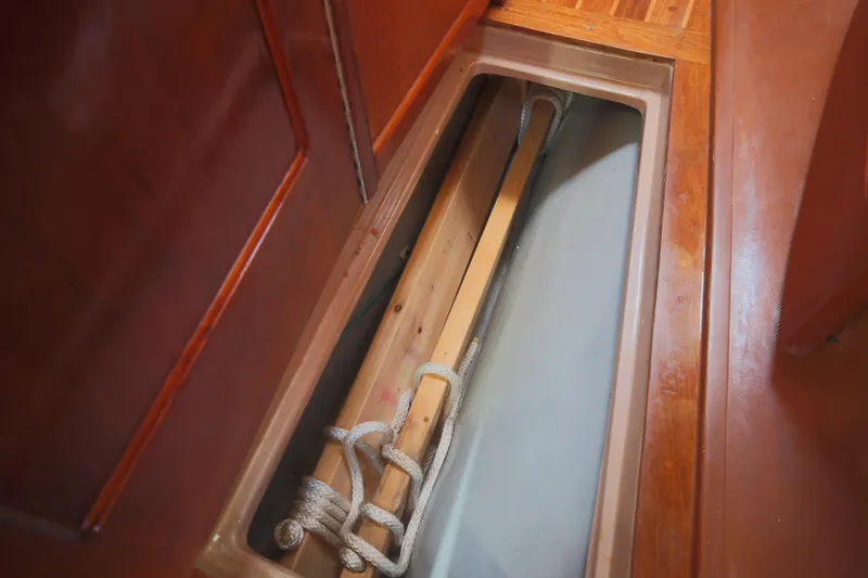Slide: The Image of Storage compartment on 1979 Westsail 32 Shipmaster with wooden and rope items. - 46