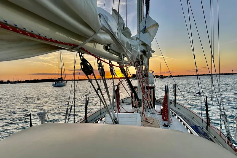 Slide: The Image of 1979 Westsail 32 Shipmaster sailboat at sunset on calm waters. - 74