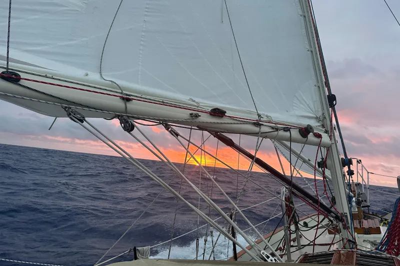 Slide: The Image of Sailing on a 1979 Westsail 32 Shipmaster at sunset, ocean waves in the background. - 76