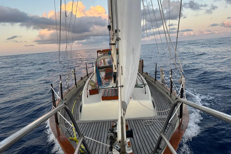 Slide: The Image of 1979 Westsail 32 Shipmaster sailing on open ocean under a colorful sky. - 78