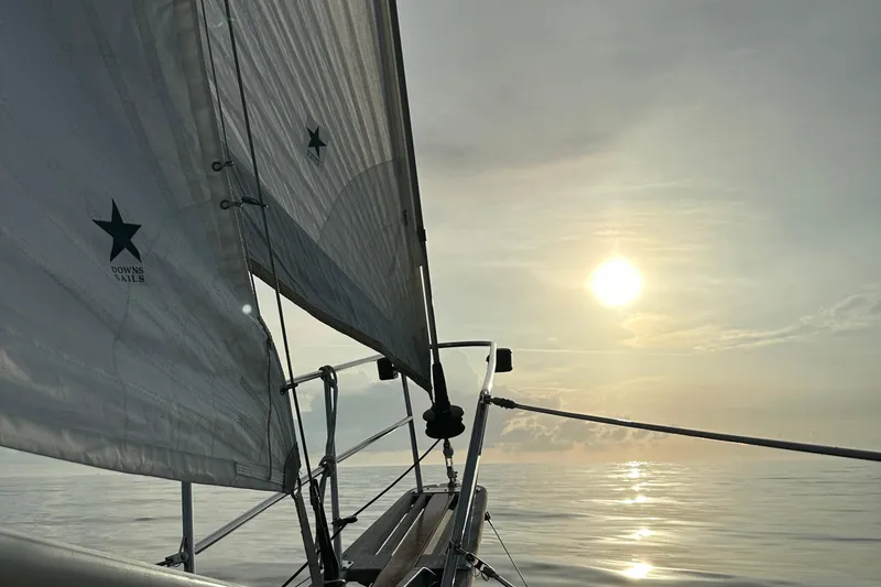 Slide: The Image of Sailing on a 1979 Westsail 32 Shipmaster at sunset, calm sea, serene atmosphere. - 80