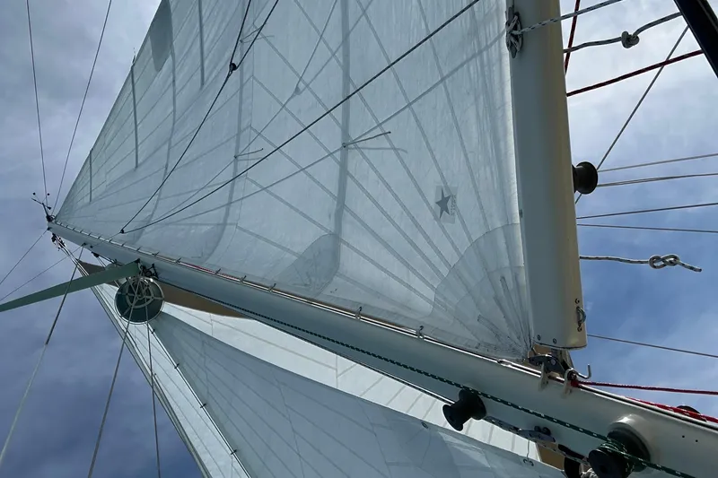 Slide: The Image of Sails of a 1979 Westsail 32 Shipmaster against a blue sky. - 86