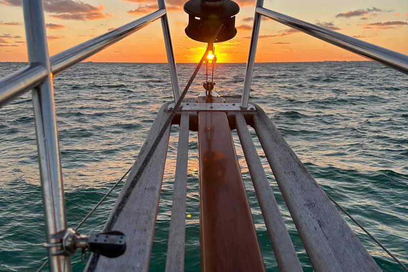 Slide: The Image of Bow of 1979 Westsail 32 Shipmaster at sunset over ocean. - 89