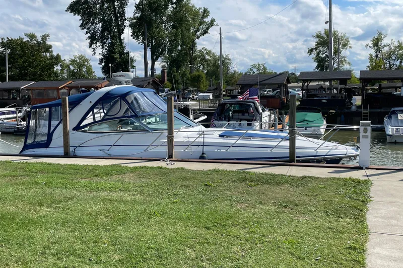 The Image of 2008 Formula 34 Performance Cruiser docked at marina, surrounded by lush greenery and other boats. - 0