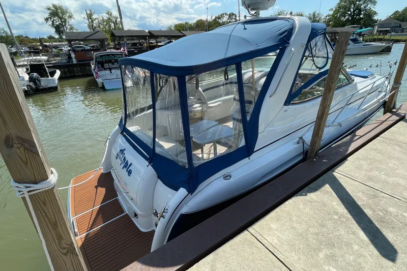 Slide: The Image of 2008 Formula 34 Performance Cruiser docked at marina, featuring blue canopy and sleek design. - 2