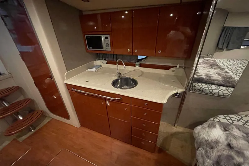 Slide: The Image of 2008 Formula 34 Performance Cruiser interior with kitchenette, microwave, and cozy sleeping area. - 22