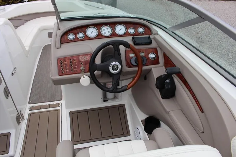 Slide: The Image of 2004 Cobalt 262 boat cockpit with steering wheel, gauges, and wood accents. - 6