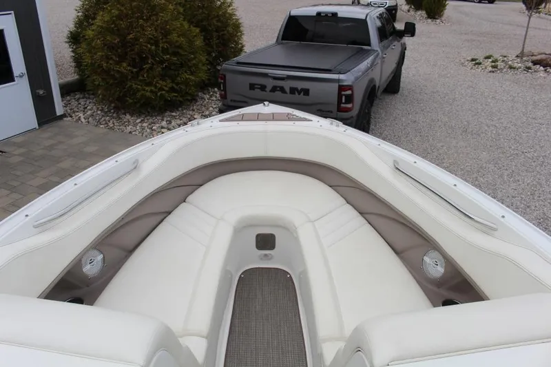 Slide: The Image of 2004 Cobalt 262 boat interior with white seating, parked near a gray Ram truck. - 7