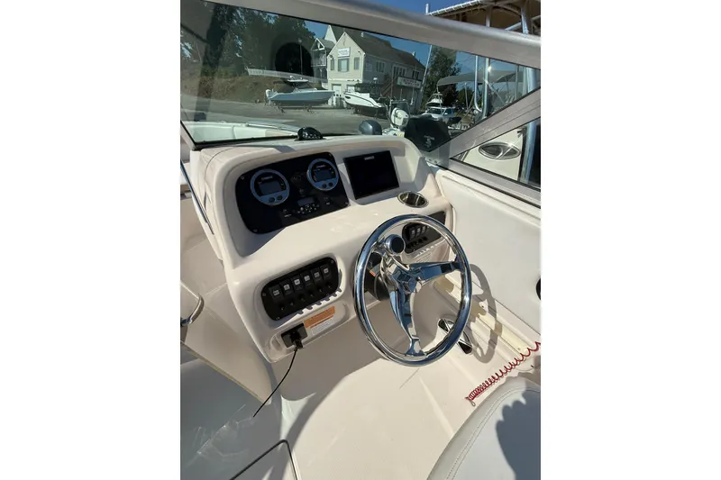 Slide: The Image of 2019 Robalo R227 Dual Console boat dashboard with steering wheel and gauges. - 10