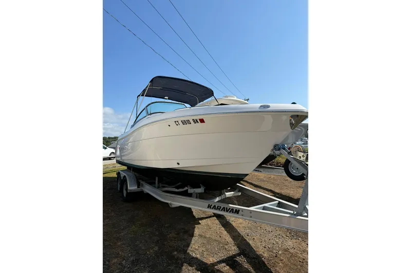 Slide: The Image of 2019 Robalo R227 Dual Console boat on Karavan trailer under clear blue sky. - 2