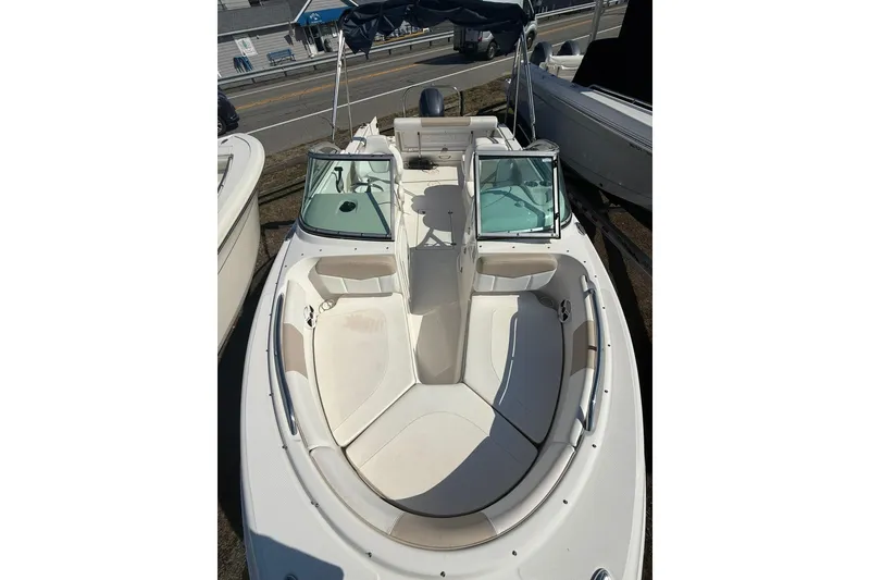 Slide: The Image of 2019 Robalo R227 Dual Console boat with spacious seating and windshield, docked outdoors. - 5