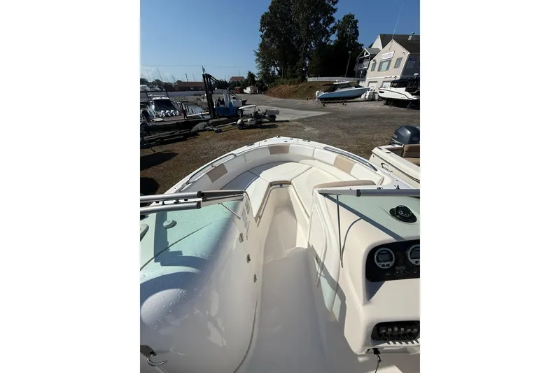 Slide: The Image of 2019 Robalo R227 Dual Console boat interior with seating and dashboard, docked outdoors. - 7