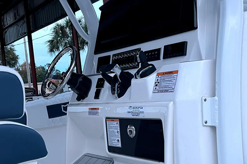 Slide: The Image of 2025 Sea Fox 288 Commander boat dashboard with steering wheel and control panel. - 3
