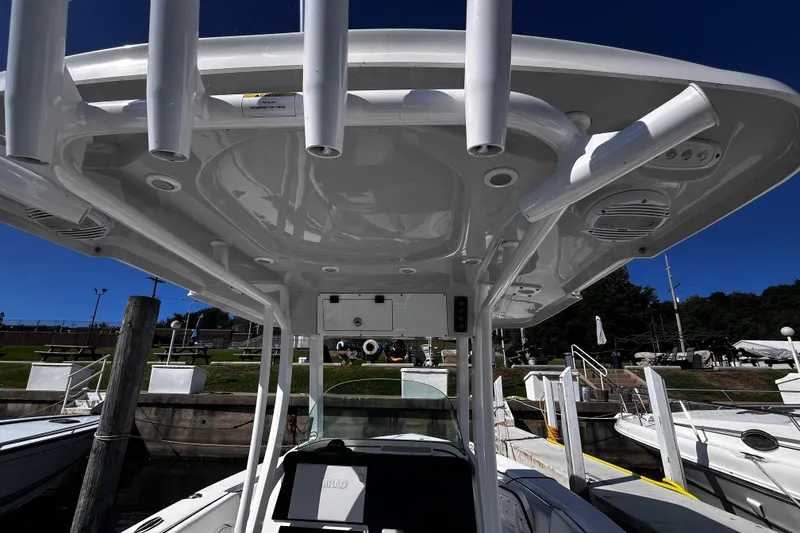 Slide: The Image of 2022 Sea Pro 259 Deep V CC boat with T-top and rod holders at a marina. - 1