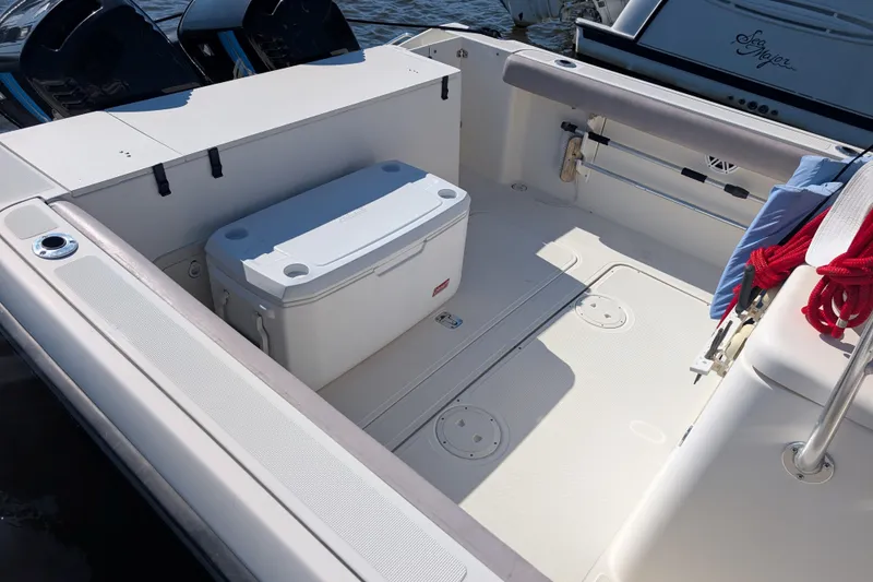Slide: The Image of 2004 Pursuit 2870 Center Console boat interior with cooler and red rope. - 11
