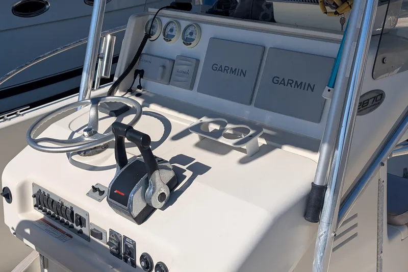 Slide: The Image of 2004 Pursuit 2870 Center Console boat dashboard with Garmin navigation and steering controls. - 4