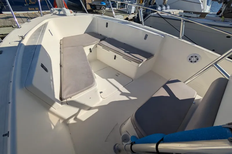 Slide: The Image of 2004 Pursuit 2870 Center Console boat interior with cushioned seating and storage compartments. - 7