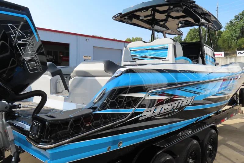 Slide: The Image of 2024 Sunsation 32CCX powerboat with vibrant blue and black design, docked outdoors. - 18