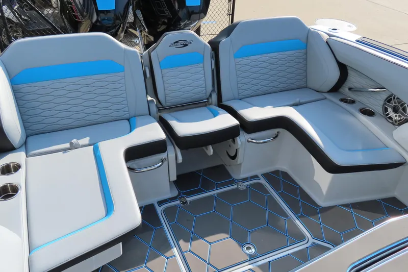 Slide: The Image of 2024 Sunsation 32CCX boat interior with blue and gray seating, cup holders, and stylish flooring. - 6