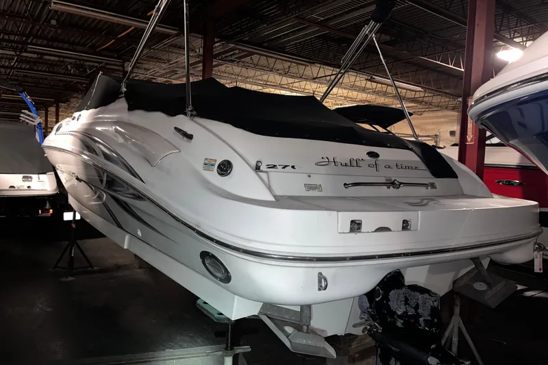 The Image of 2002 Sea Ray 270 Sundeck boat stored indoors, side view with registration number visible. - 0