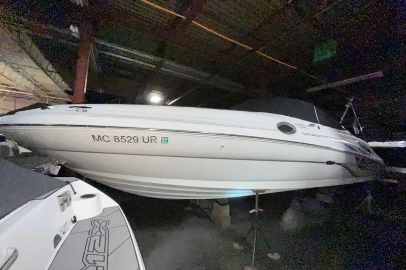 Slide: The Image of 2002 Sea Ray 270 Sundeck boat in storage, rear view with cover, indoors. - 2