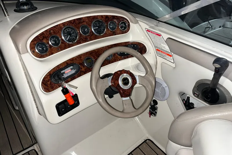 Slide: The Image of 2002 Sea Ray 270 Sundeck dashboard with steering wheel and control panel. - 4