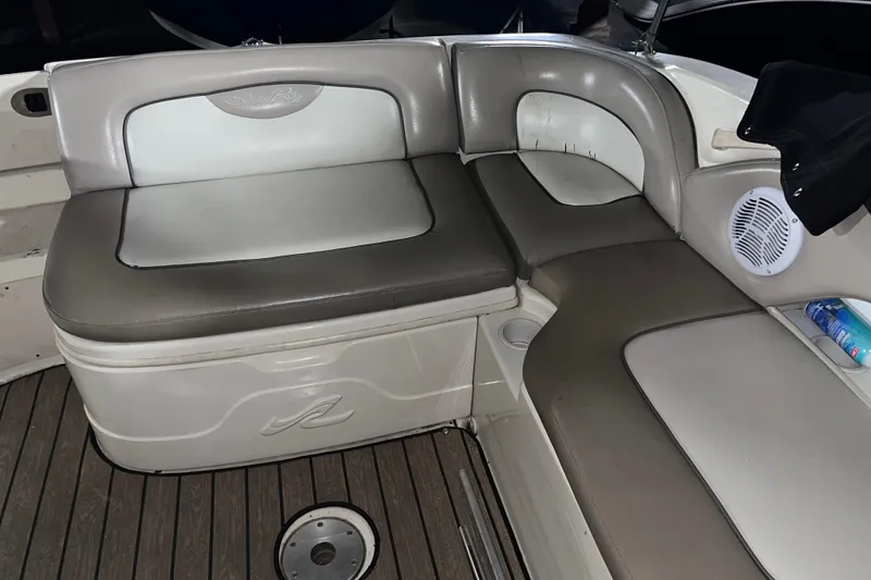 Slide: The Image of 2002 Sea Ray 270 Sundeck interior seating with gray cushions and wood flooring. - 7