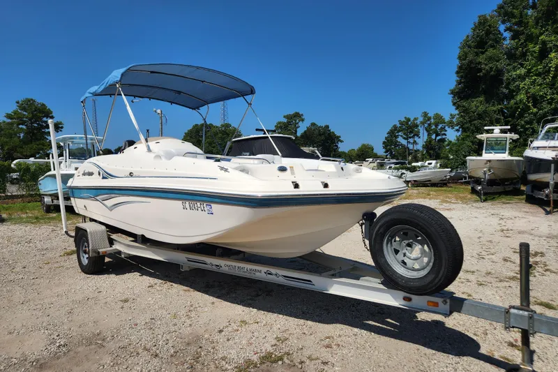 Slide: The Image of 2007 Hurricane FunDeck GS 194 O/B boat on trailer with blue canopy in outdoor setting. - 2