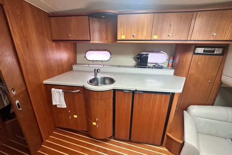 Slide: The Image of 2007 Tiara Yachts 3900 Sovran interior kitchen with wood cabinetry and compact appliances. - 20