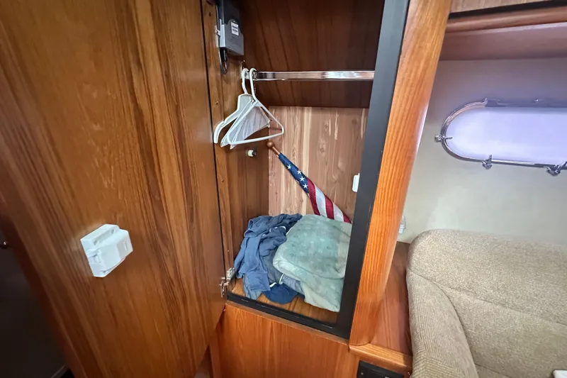 Slide: The Image of 2007 Tiara Yachts 3900 Sovran cabin closet with clothes, hangers, and American flag. - 25