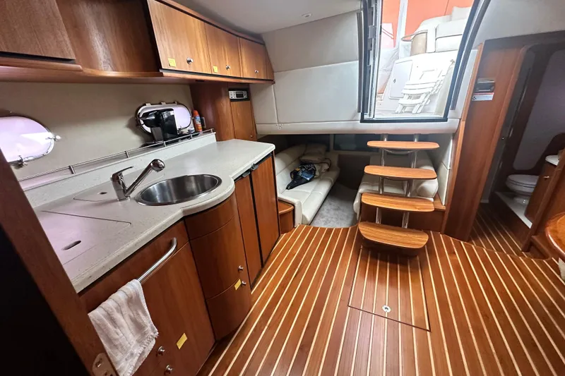 Slide: The Image of 2007 Tiara Yachts 3900 Sovran interior with kitchenette, wooden flooring, and stairs to deck. - 27